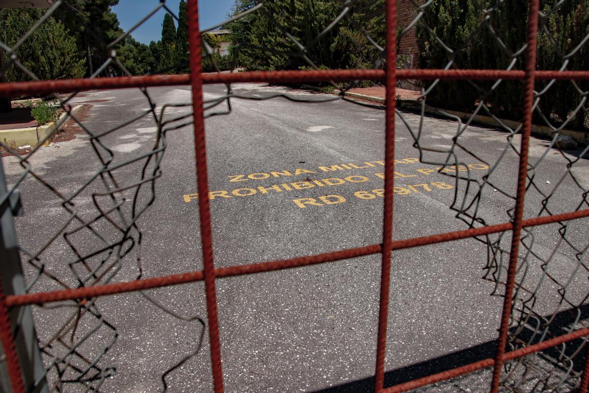 Entrada a la antigua base, donde todavía se lee en el asfalto la inscripción de &quot;zona militar&quot;.