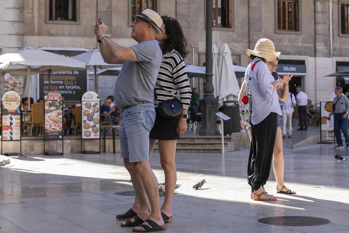 Turistas hacen fotos en el centro de València.