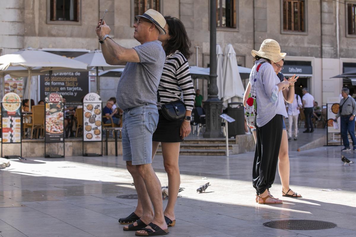 Turistas hacen fotos en el centro de València.