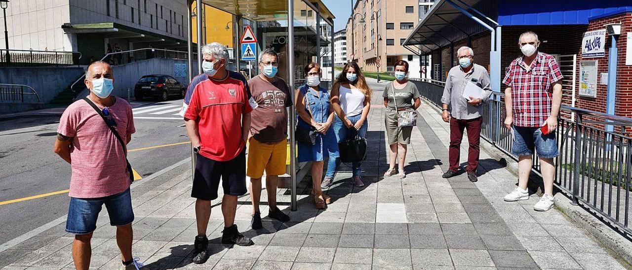 Por la izquierda, Antonio Gil, Javier Muñiz, Alejandro Ferrer, Teresa Domínguez, Nuria Rial, Paquita Muñiz, José Ramón Fernández y Manolo Miranda, ayer, en el barrio de La Luz, junto a una marquesina de autobús.