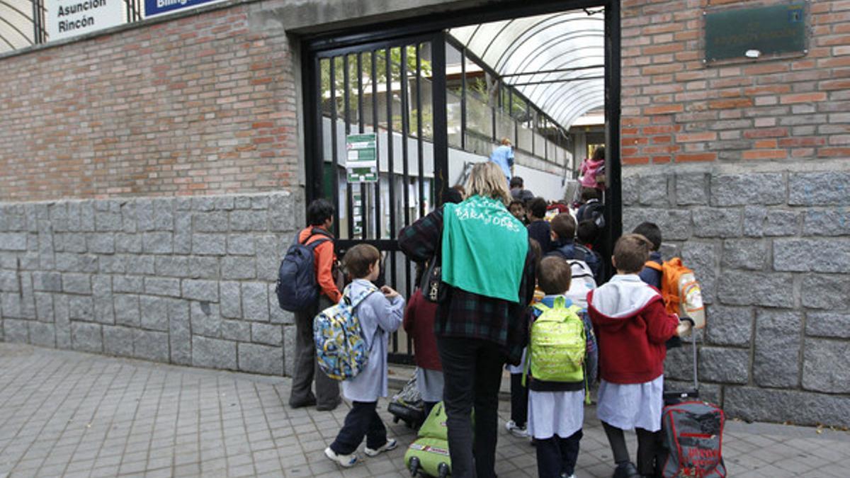Padres y niños, a la entrada de un colegio de Madrid, este jueves.