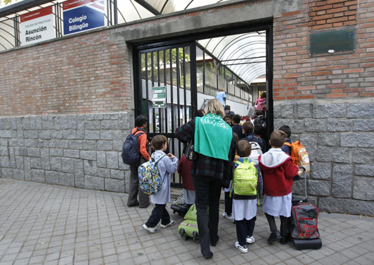 Pares i nens, a l’entrada d’una escola de Madrid, aquest dijous.