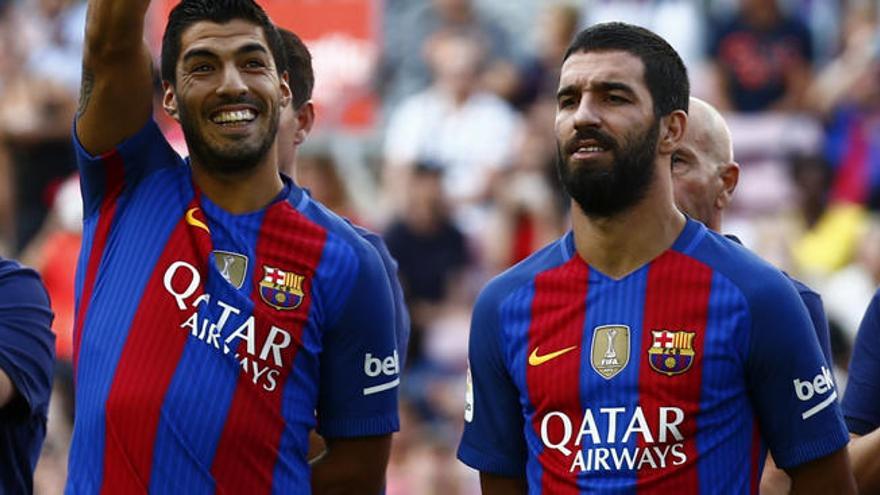 Turan con Luis Suárez.