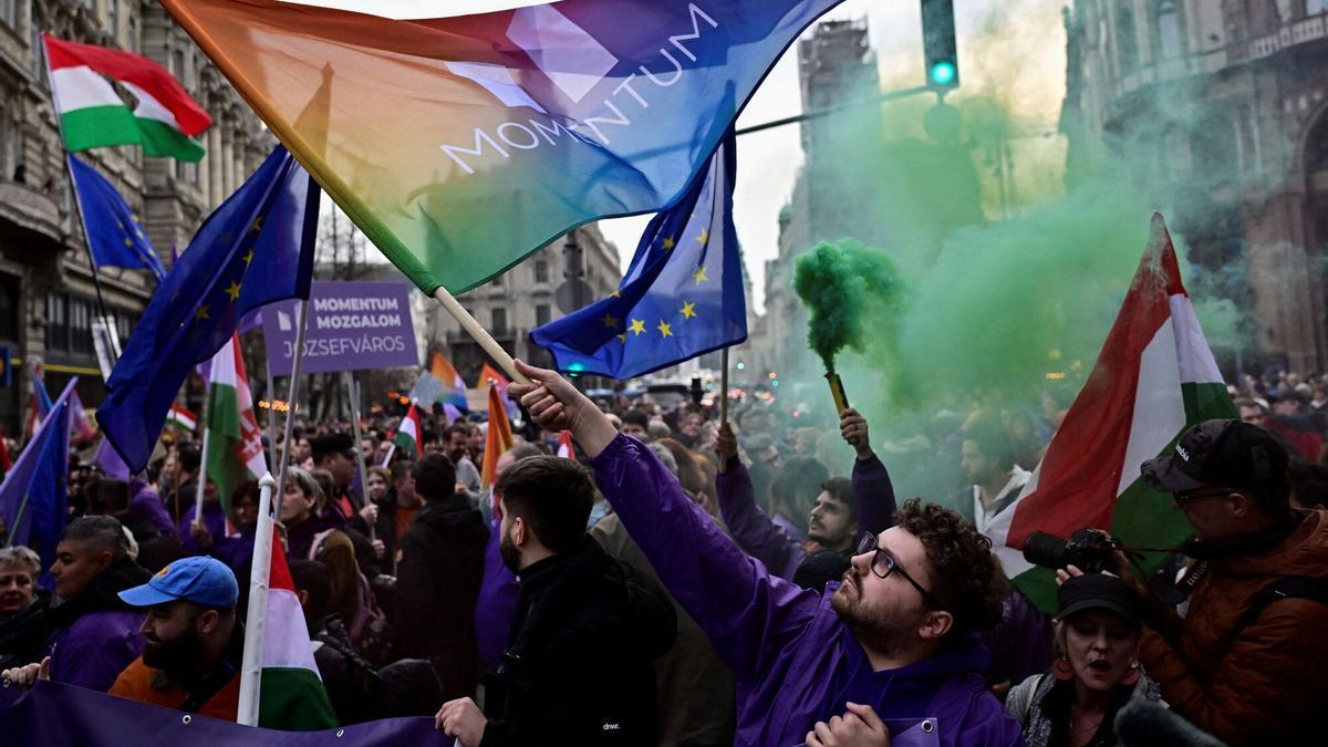 Un hombre ondea una bandera durante una manifestación después de que el Parlamento húngaro aprobara una ley que prohíbe a las comunidades LGBTQ+ celebrar la marcha anual del Orgullo y permite una restricción más amplia de la libertad de reunión, en Budapest