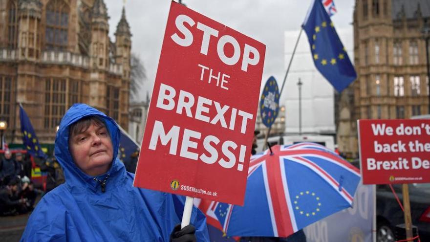 Una manifestante sostiene una pancarta con el lema &quot;Detengamos el lío del Brexit&quot;, ayer, en Londres // Neil Hall (Efe)