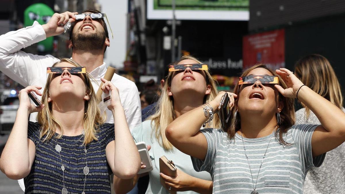 Varias personas miran al cielo durante un eclipse anterior.