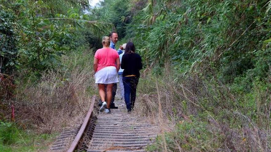 Vecinos de Teis pasean por las antiguas vías del tren. // M.G. Brea