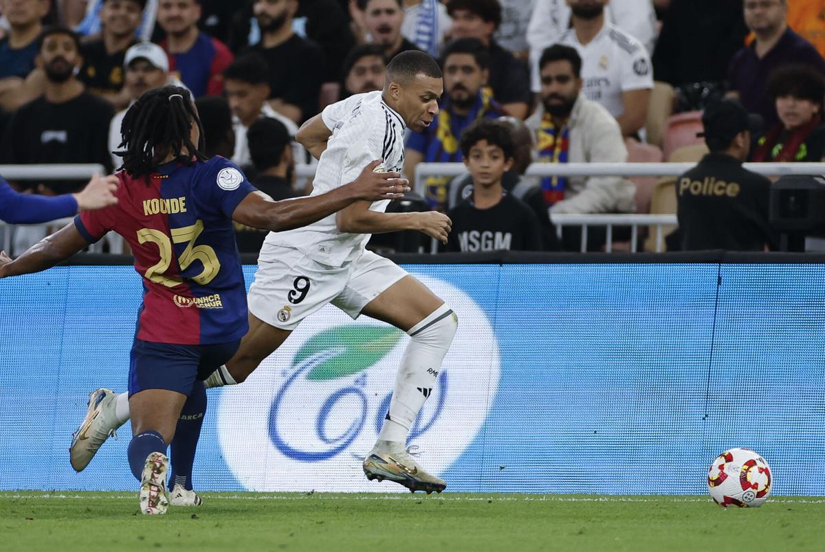 El delantero francés del Real Madrid Kylian Mbappé (d) se escapa de Jules Koundé, del FC Barcelona, durante el partido de la final de la Supercopa de España de fútbol entre el Real Madrid y el FC Barcelona, este domingo en Yeda, Arabia Saudí. EFE/ Alberto Estévez. (Barcelona)
