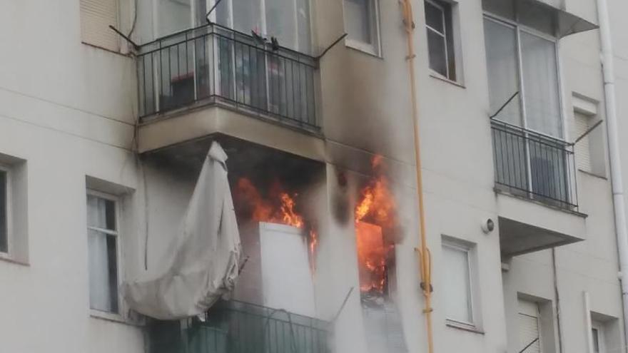 Les flames sortien per una de les finestres del bloc d&#039;habitatges afectat pel foc