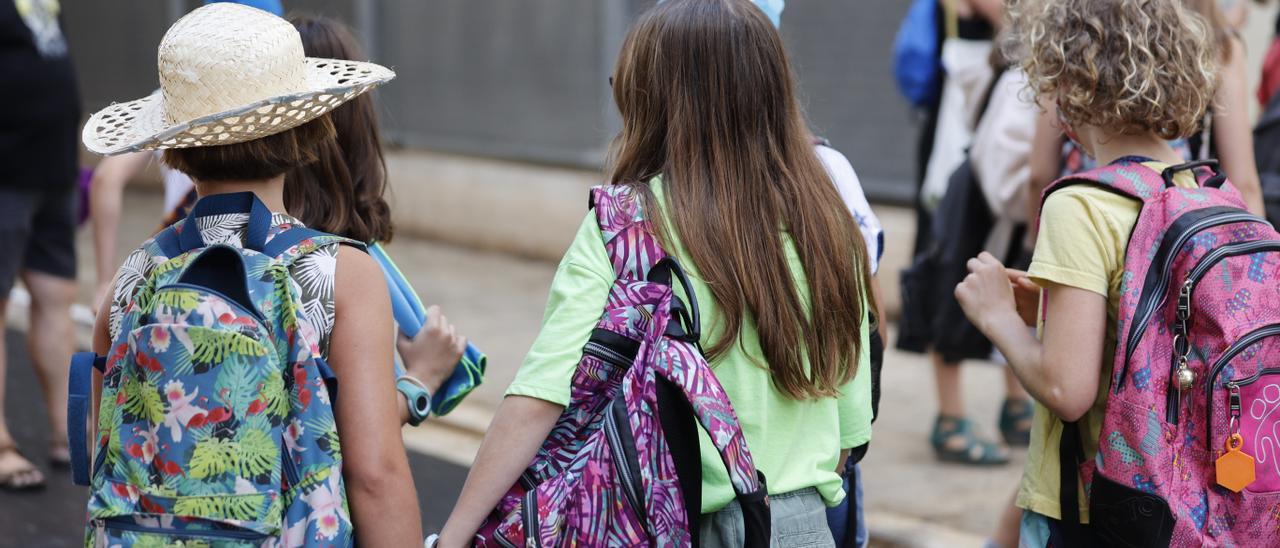 Tres alumnas a las puertas de un centro educativo, en València, un día de calor.