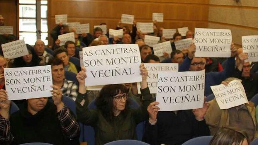 Comuneros de Budiño y Atios muestran carteles, ayer, en el pleno. // D.P.