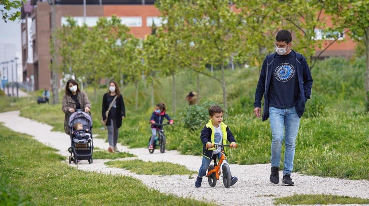 Familia pasean con sus hijos por el Parc Central de Igualada, el primer dia que puedieron salir los niños menores a la calle.