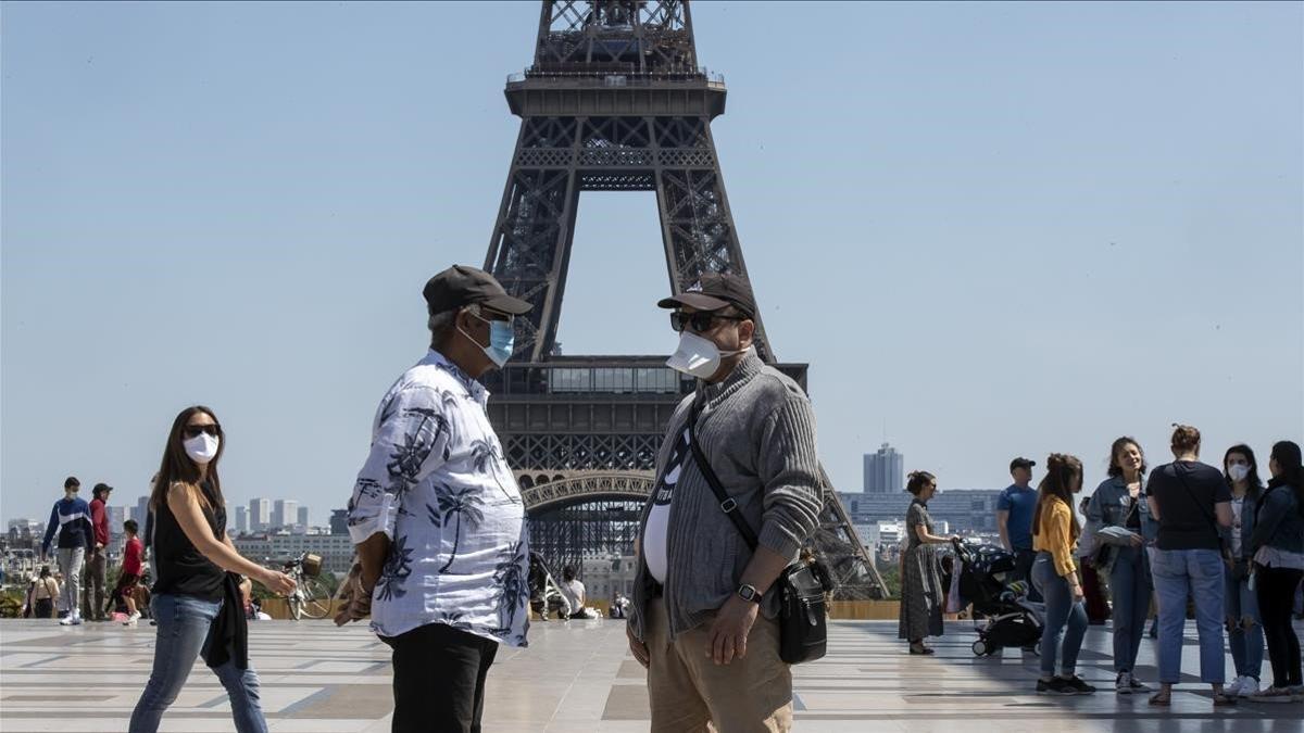 Gente llevando máscaras frente a la Torre Eiffel, en París, el 17 de mayo del 2020