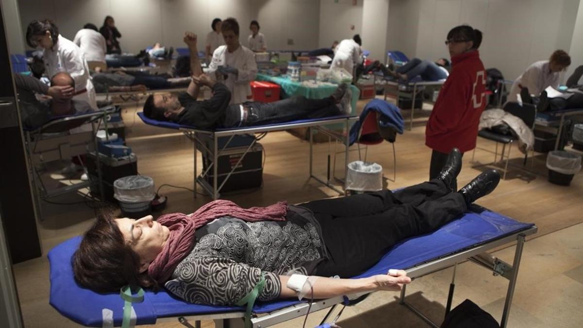 Varios ciudadanos donan sangre en el Palau Robert, en Barcelona.