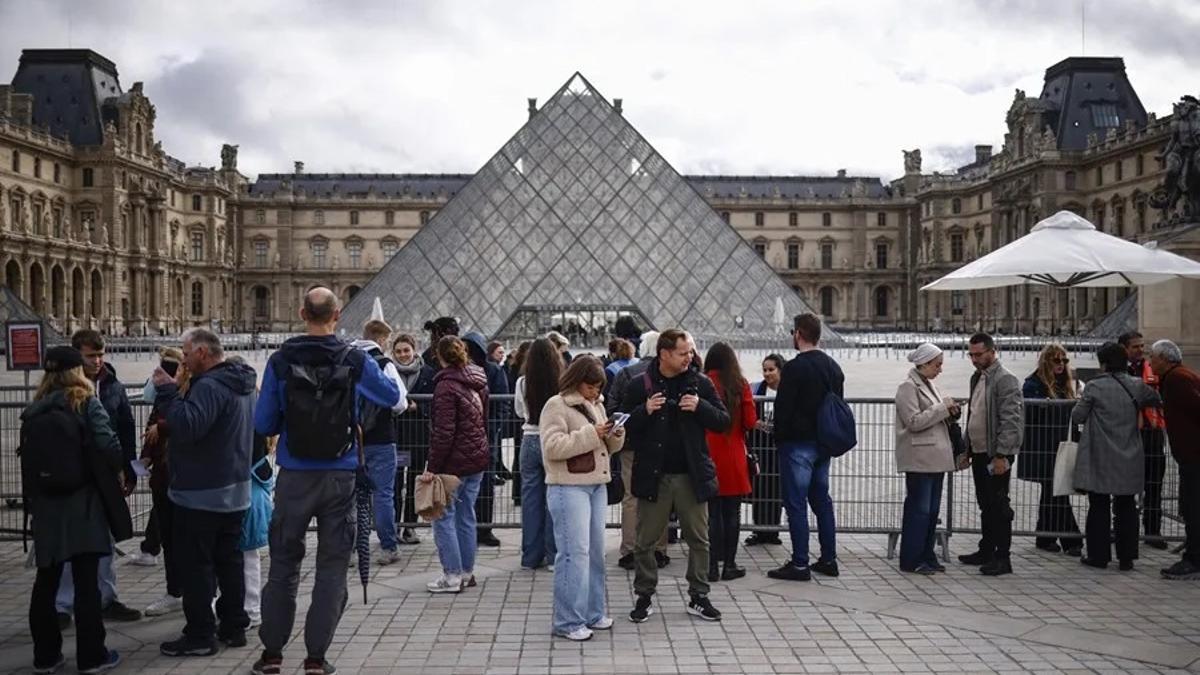 Visitantes permanecen fuera del Museo del Louvre, tras el robo.