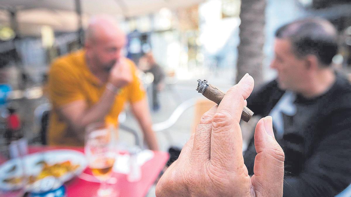 Un cliente fuma en una terraza de un bar en una fotografía de archivo.