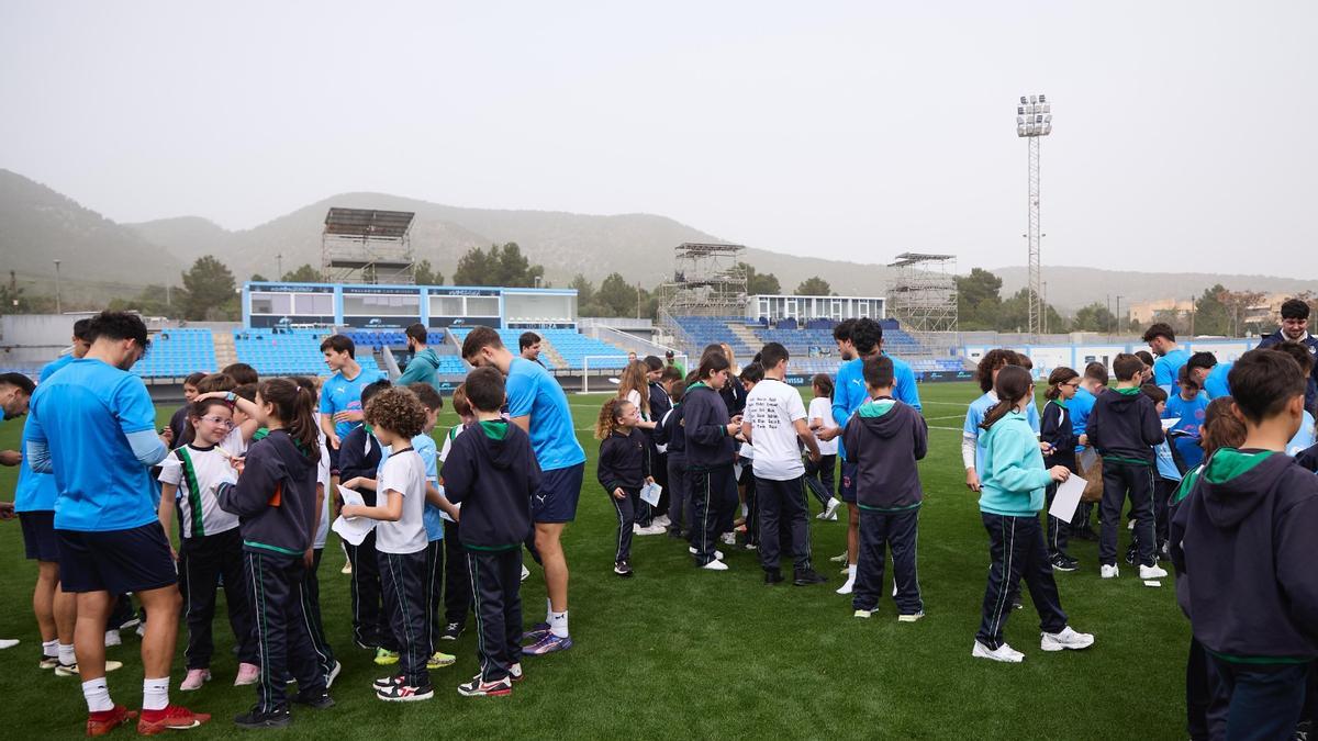 Los alumnos con los futbolistas sobre el césped de Can Misses.