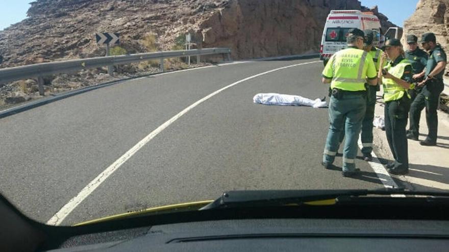 Agentes de la Guardia Civil y ambulancia de la Cruz Roja, junto al cadáver del ciclista, tapado con una sábana.