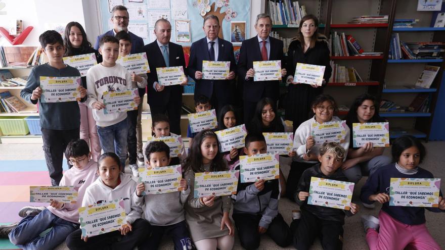 Por la derecha, de pie, Lourdes García, Abel Fernández, Alfredo Canteli, Pablo Junceda y Ramsés García, junto a los alumnos de 6º de Primaria del colegio de San Pedro de los Arcos participantes en los talleres sobre economía.  | LUISMA MURIAS