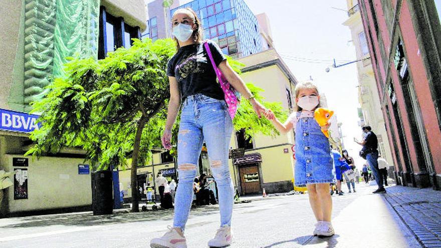 Una madre y su hija pasean portando mascarillas por el centro de Santa Cruz de Tenerife.