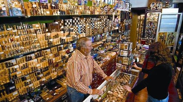 Mucho juego 8 Ramon Mallart atiende a una clienta en su comercio de Jaume I, 17.