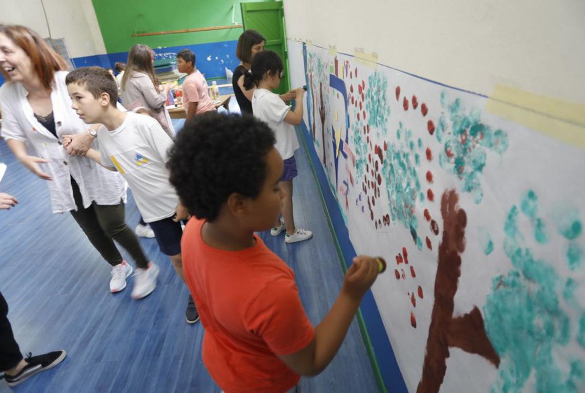 Pequeños del San Cristóbal y del Palacio Valdés pintan un mural. | R. S.