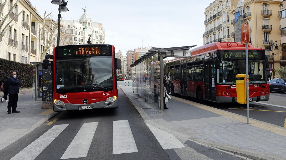 Dos autobuses de la EMT recogen pasajeros en dos paradas del centro.