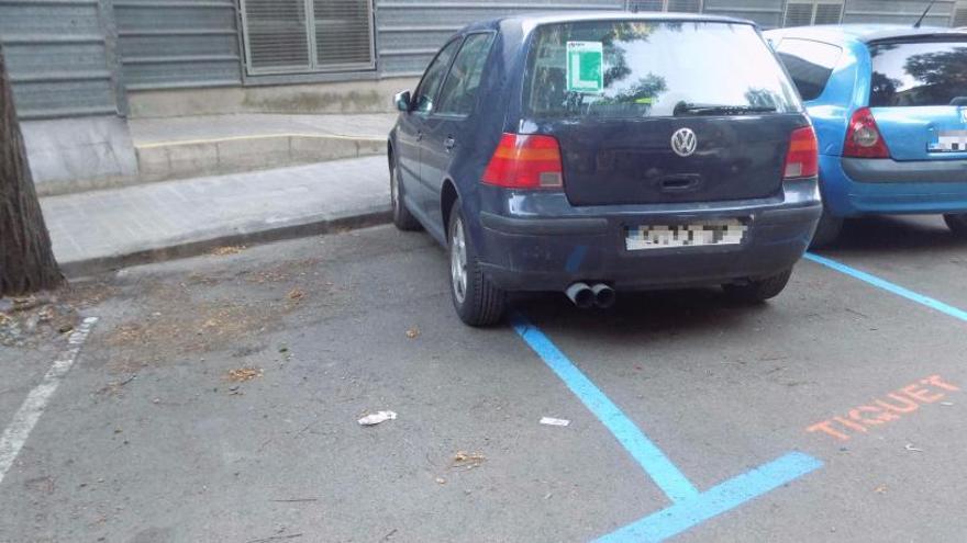 Dos vehicles aparcats en places de zona blava a Manresa.