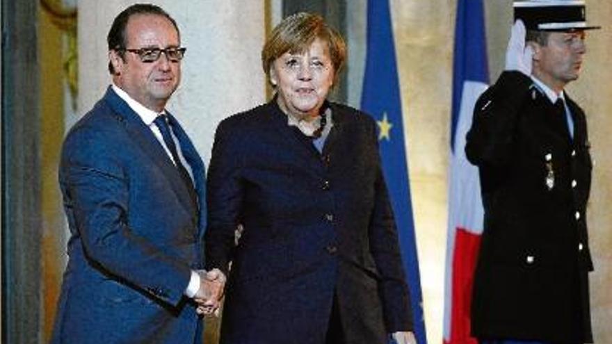 Hollande i Merkel se saluden abans de la seva reunió al Palau de l&#039;Elisi.