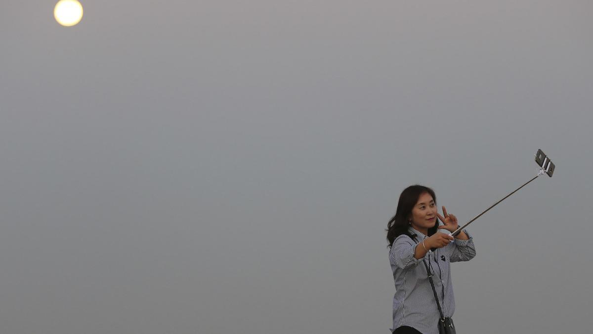 Una turista coreana se hace un selfi con la superluna de fondo en Dubái, ayer.