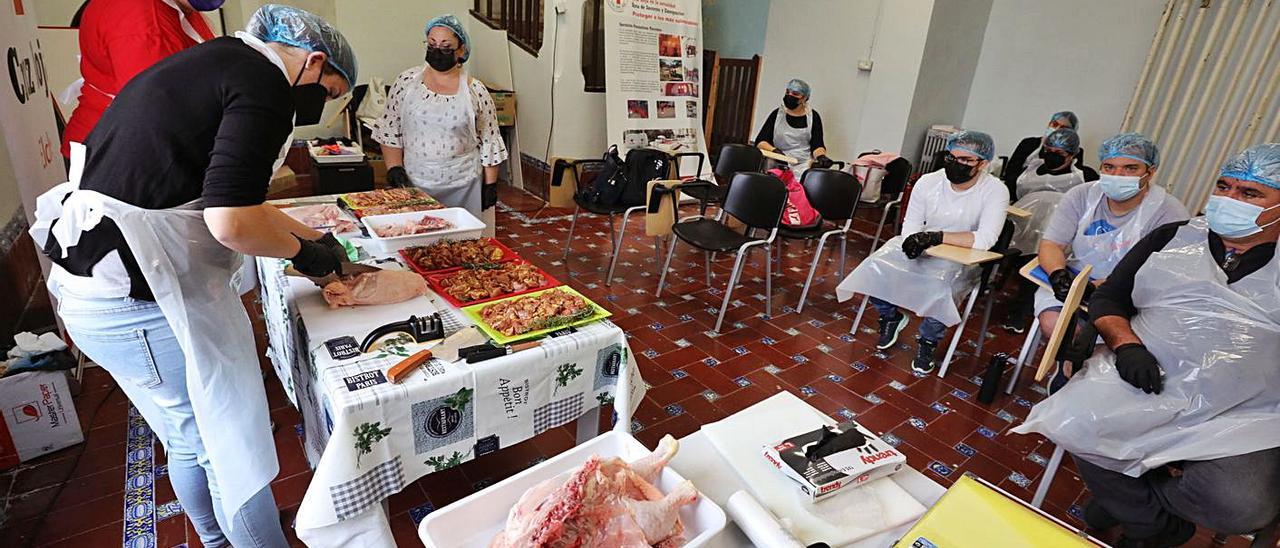 Alumnos durante las formaciones de carnicería y pescadería esta semana en Cruz Roja.  | ANTONIO AMORÓS