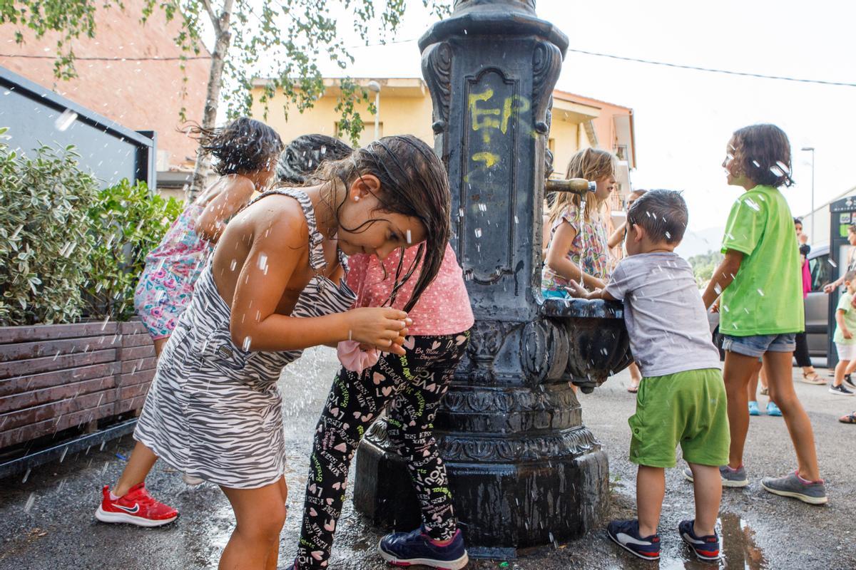 Una niña se refresca la tarde más calurosa del verano en Sant Celoni.