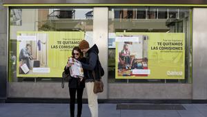 Tourists look at a city map in front of a Bankia bank branch in the Andalusian capital of Seville, southern Spain February 17, 2016. REUTERS/Marcelo del Pozo