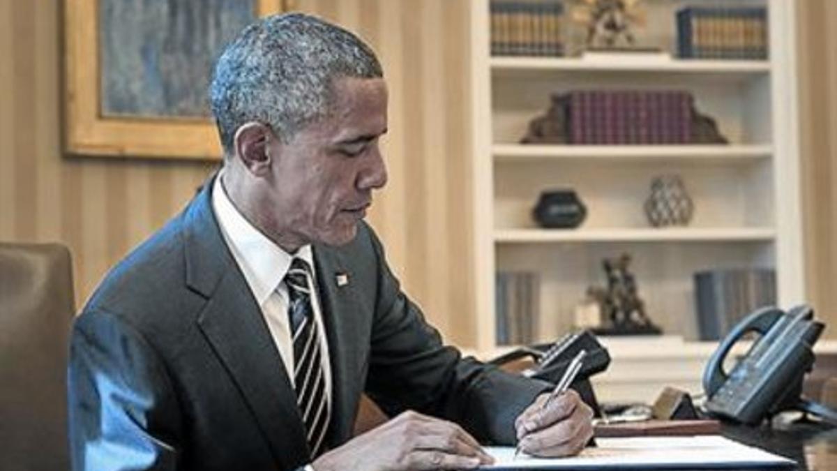 Obama firma una orden ejecutiva en el Despacho Oval, este jueves.