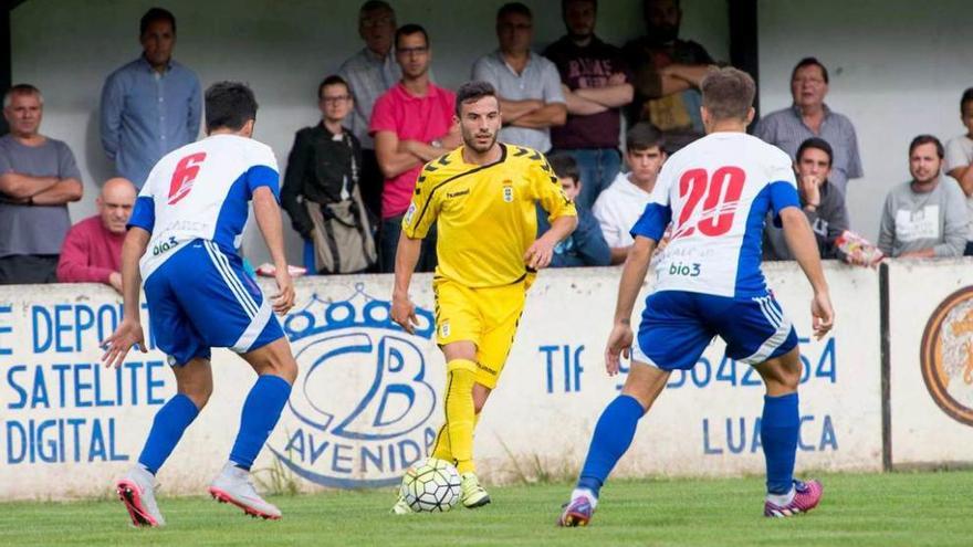 Fernández, con el balón, ante dos rivales de la Ponferradina.