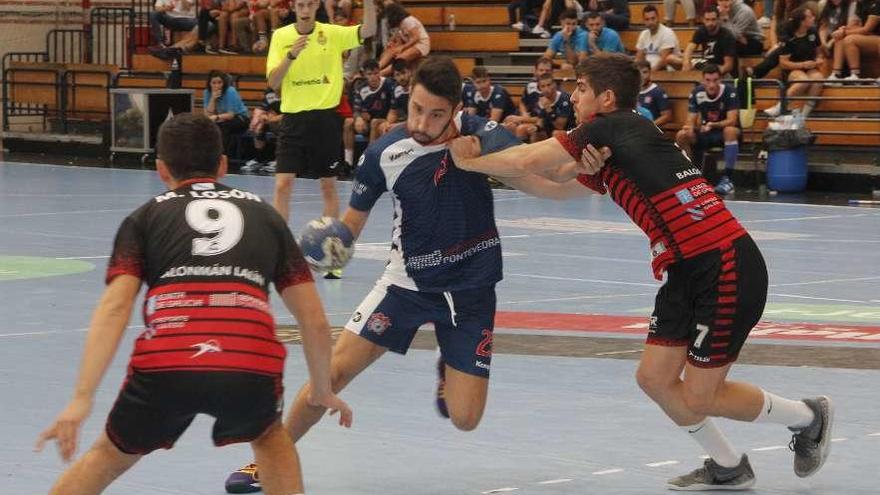 Martín Losón y Uxío en tareas defensivas, ayer en Cangas, frente al local David Veloso. // Santos Álvarez