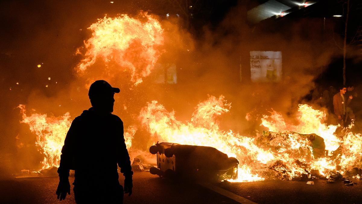 Contenedores incendiados durante las protestas contra la reforma de las pensiones en París, Francia