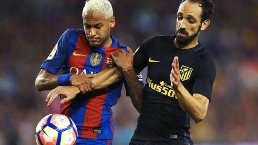 El brasileño Neymar y el crevillentino Juanfran Torres pugnan por un balón en el partido de anoche en el Camp Nou entre Barça y Atlético.