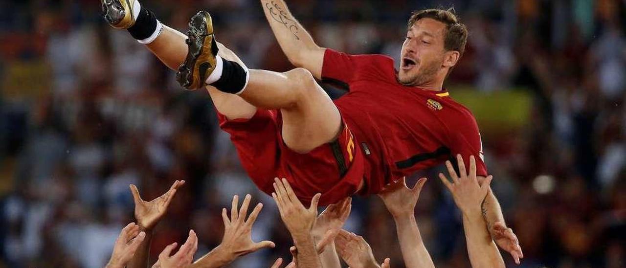 Totti es manteado por sus compañeros.