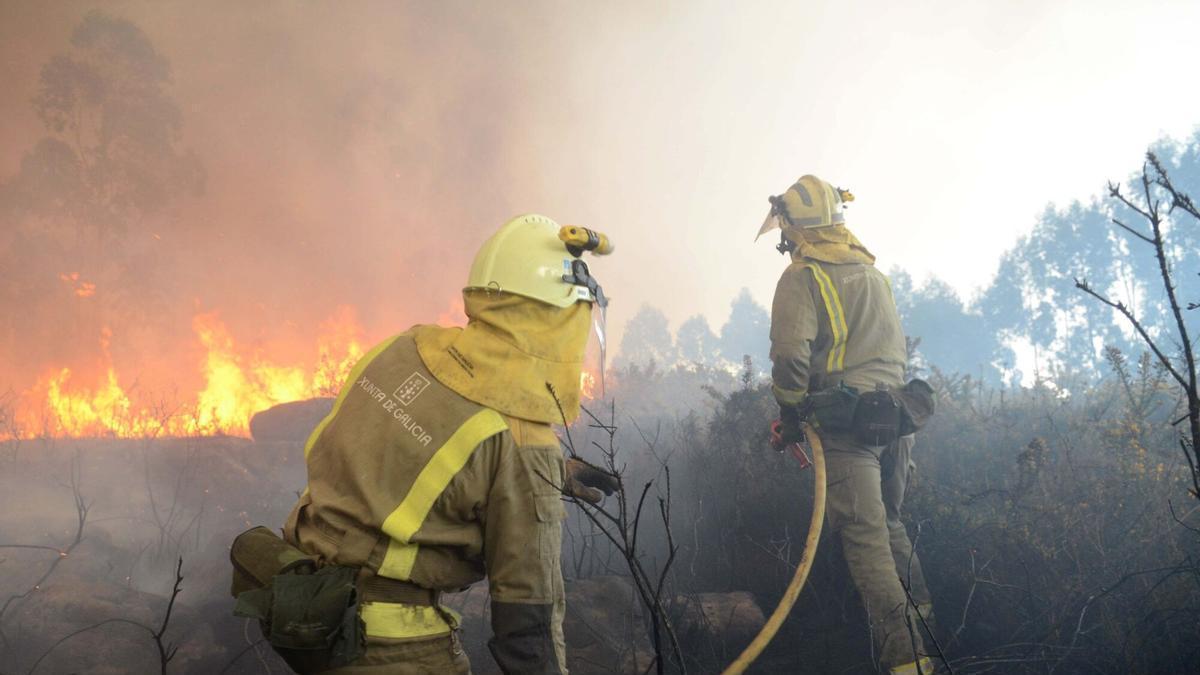 Bomberos foresales trabajan en la extinción de un incendio en Rianxo
