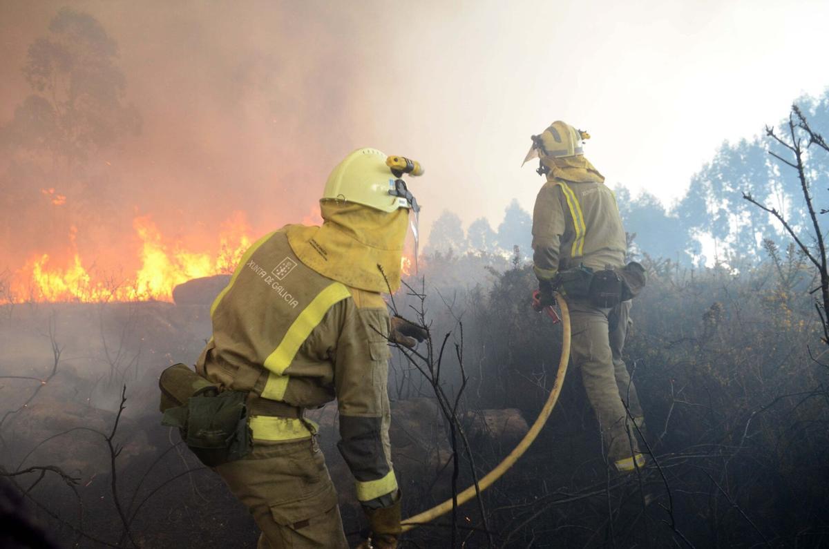 Bomberos foresales trabajan en la extinción de un incendio en Rianxo.