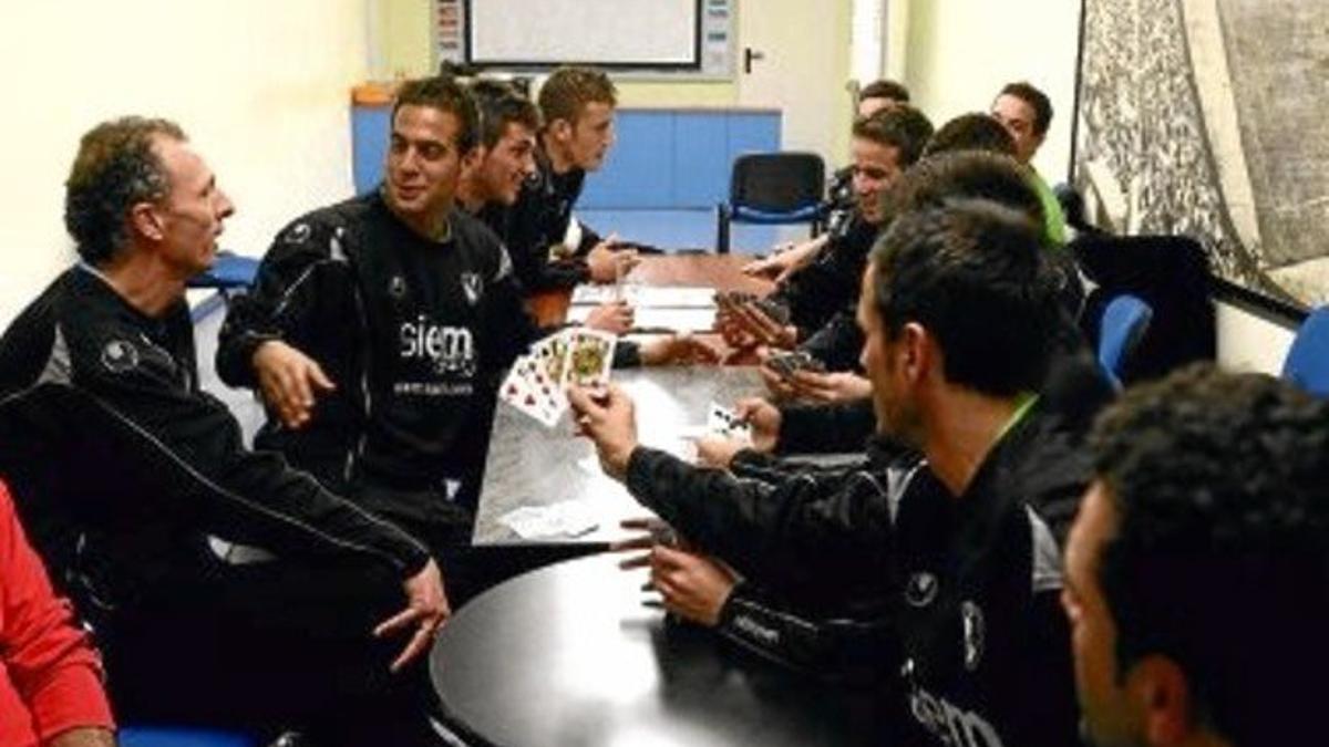 Encierro. El técnico y los jugadores se entretienen jugando a las cartas en las instalaciones del estadio Olímpic de Terrassa.