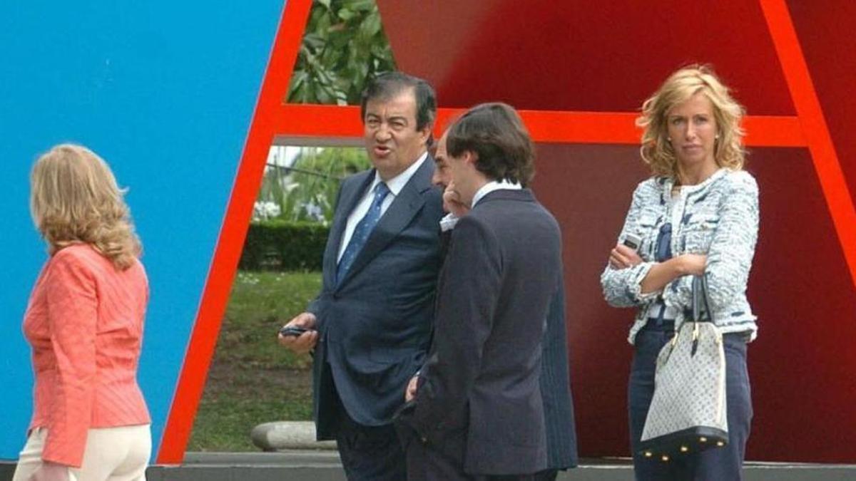 María Porto, a la derecha, y Álvarez-Cascos, en el centro, junto a otras personas en la inauguración de la exposición de Robert Indiana en Madrid en 2006. A la derecha, la factura que pasó Cascos por el proyecto de las bases de la escultura y el primer pago de Kiss FM por patrocinar la exposición.