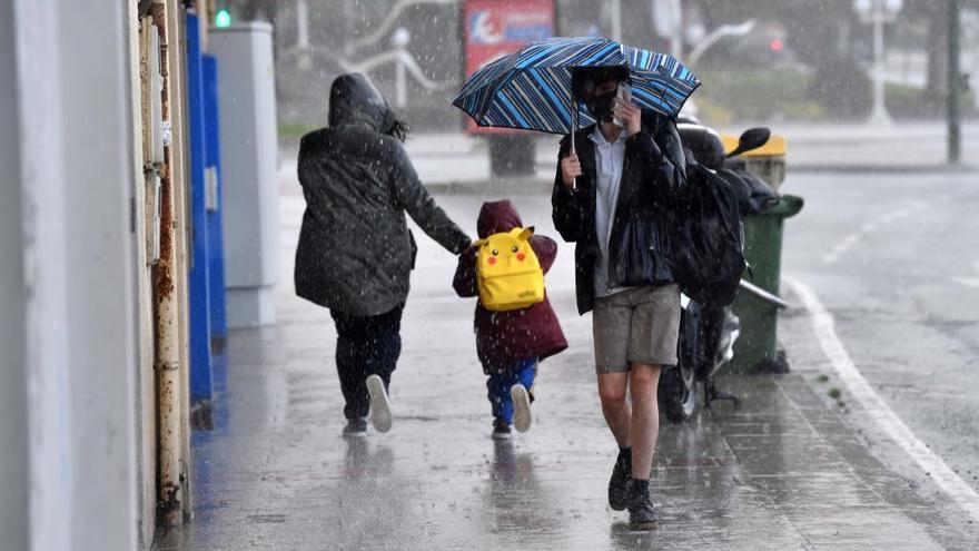 Varias personas bajo la lluvia en A Coruña.