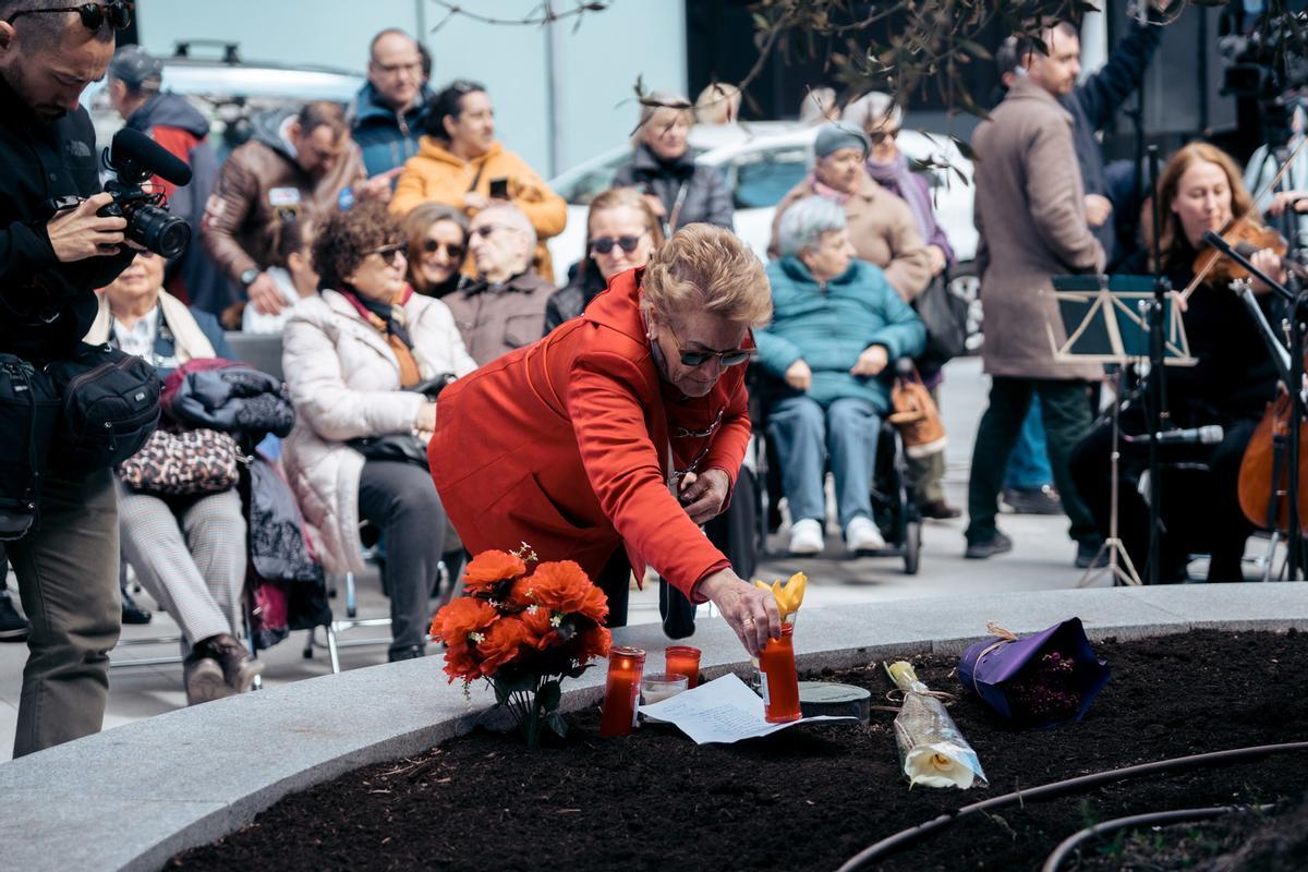 Una mujer enciende una vela durante un homenaje por las víctimas del atentado del 11M en su 20 aniversario, en la placa conmemorativa de la calle Téllez, a 11 de marzo de 2024, en Madrid (España). La ofrenda foral ha sido organizada por la Asociación 11-M