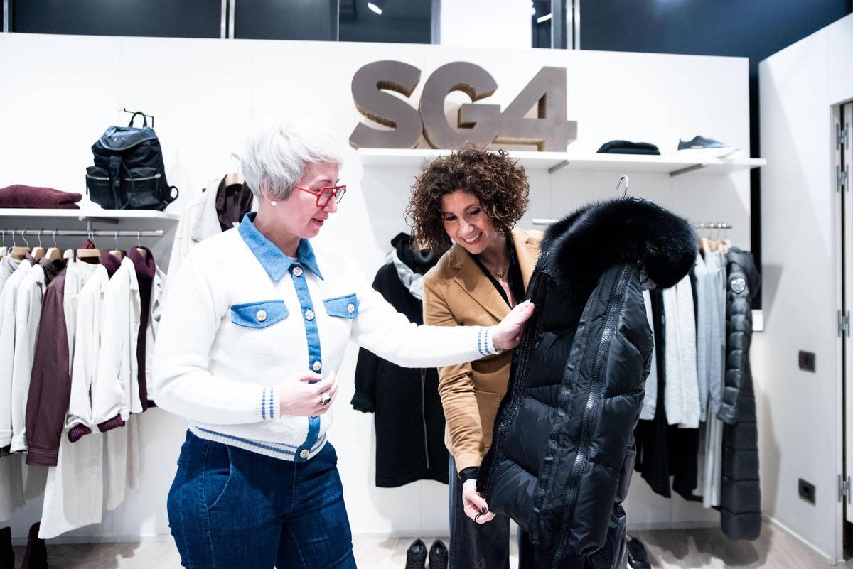 Una clienta mirant una jaqueta a la botiga de moda SG4