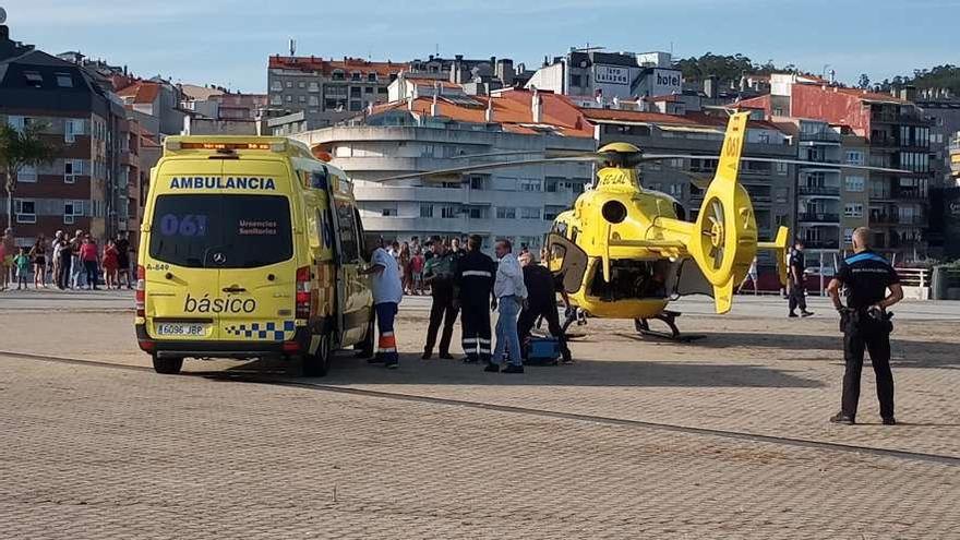 Las ambulancias y el helicóptero que se llevó al herido tras aterrizar en la Praza do Mar. // FdV