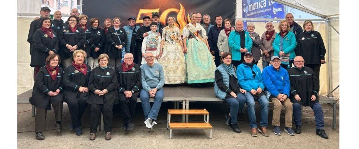 Imagen de los actuales y antiguos dirigentes del Portal con las falleras mayores ante el logo de los 50 años