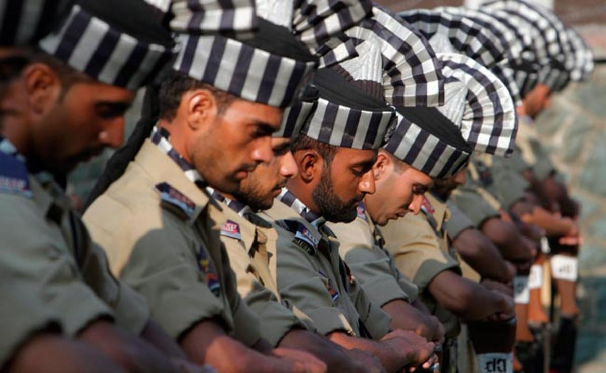 Membres de la policia índia participen en la cerimònia del Dia dels Màrtirs al cementiri dels Màrtirs a Srinagar, la capital estival del Caixmir, Índia.