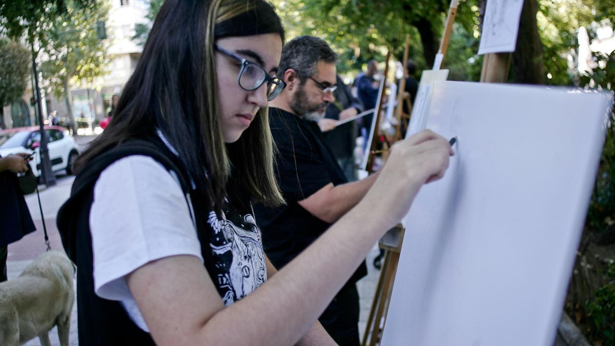 Una joven dibuja en el paseo de Cánovas.